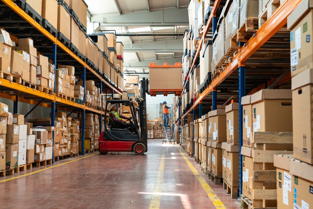 Forklift moving palletized inventory through a warehouse aisle